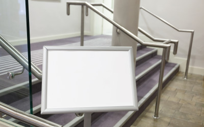 Blank billboard in the corridor with stairs between conference rooms.