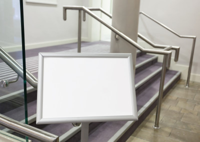 Blank billboard in the corridor with stairs between conference rooms.